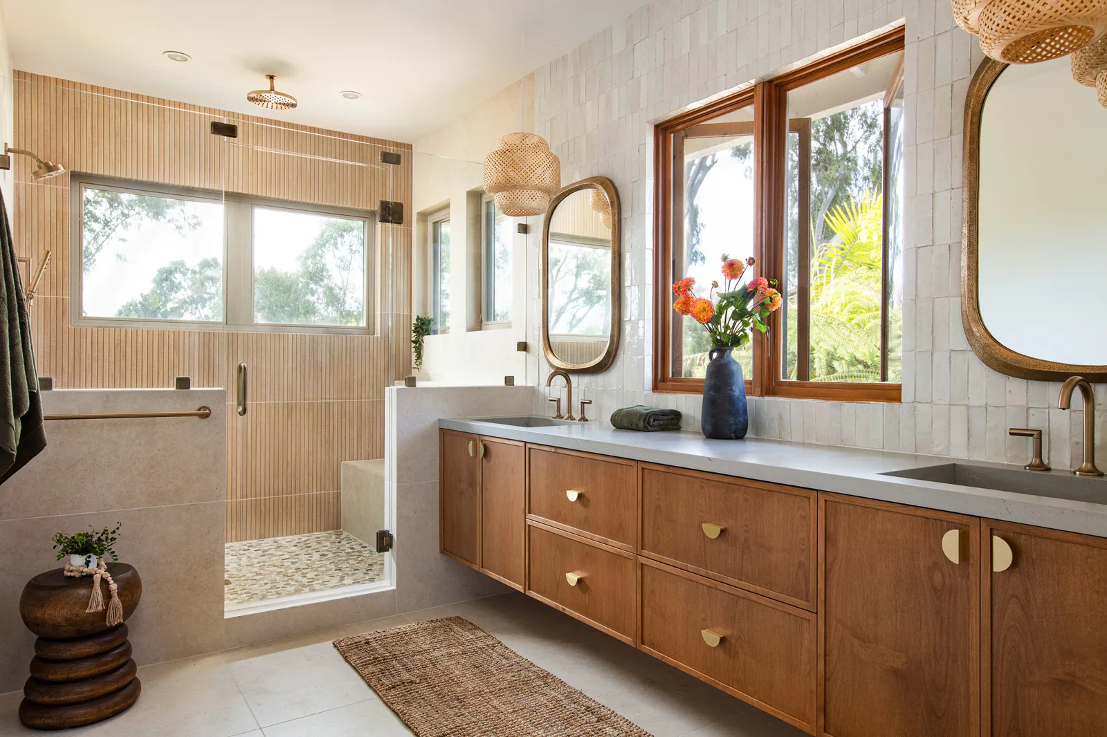 Remodeled bathroom with a tiled walk-in shower, a wood vanity and a wide window